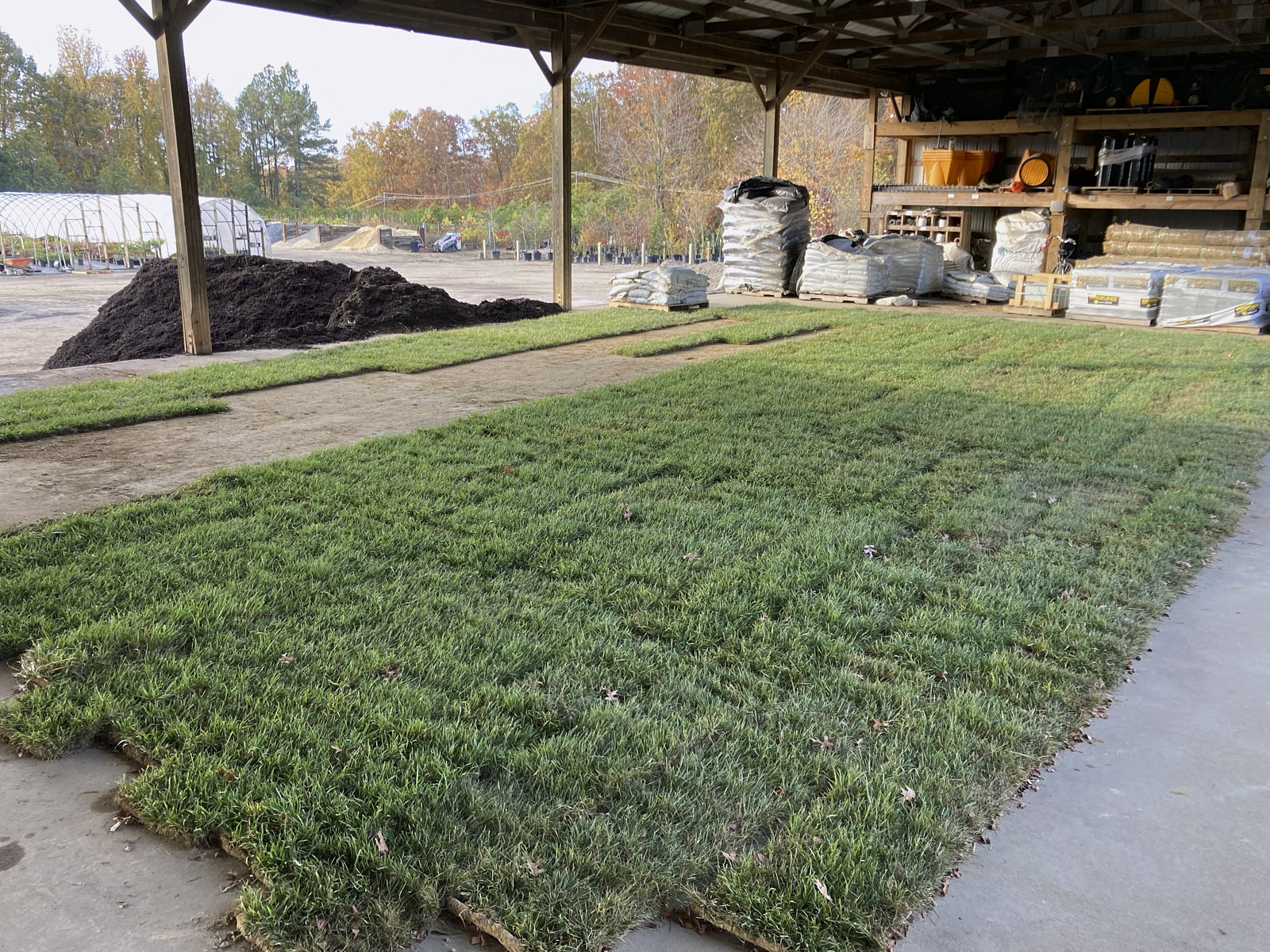 Plenty Of Grass Turf Covers In A Large Area With Overhead Cover And Pillars With A Mulch Mound Nearby For Sod Installation